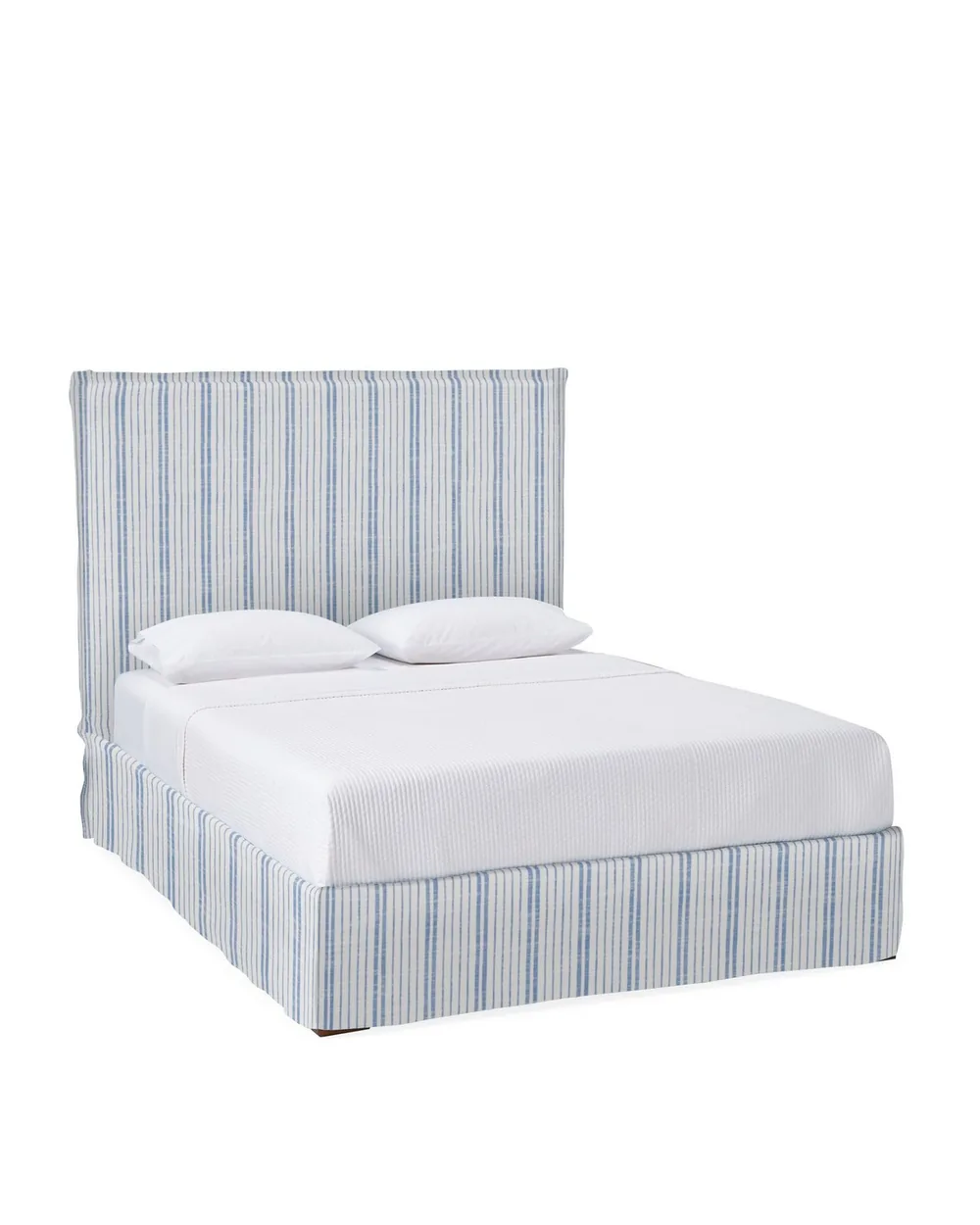Slipcovered bed with a soft striped upholstered frame