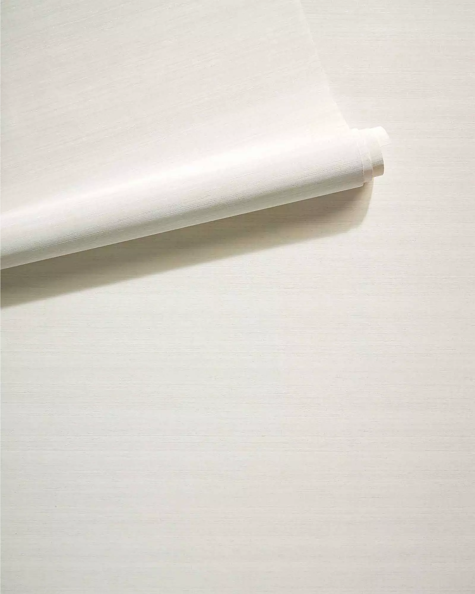Off-white silk-textured wallcovering, partly unrolled